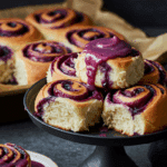 Rolls aux myrtilles avec glaçage chocolat blanc coulant sur spirales dorées