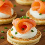 Blinis au saumon fumé sous son lit de neige élégants sur plateau d'ardoise