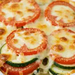 Gratin courgettes tomates doré plat céramique fromage fondu légumes colorés
