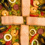 Riz sauté façon paëlla au saumon dans une poêle noire traditionnelle
