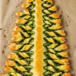 Sapin feuilleté au pesto doré avec branches torsadées sur bois rustique