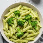 Sauce à la crème de brocoli et penne dans un bol blanc avec parmesan râpé