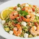 Couscous estival et crevettes dans un bol blanc sur table en bois