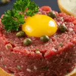 Filet américain traditionnel servi sur pain artisanal avec garnitures