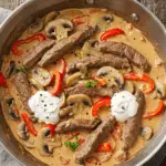 Filet de bœuf Stroganov élégamment dressé sur assiettes blanches avec sauce crémeuse