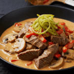 Filet de bœuf Stroganov élégamment dressé sur assiettes blanches avec sauce crémeuse