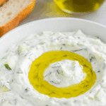 Sauce Tzatziki Grecque authentique dans bol blanc avec concombre herbes fraîches