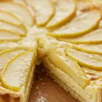 Tarte pommes ultra crémeuse texture fondante part découpée surface dorée