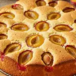 Tôt-fait aux mirabelles doré saupoudré sucre glace sur table rustique