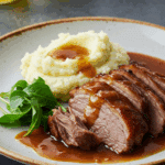 Épaule de porc braisée fondante dans cocotte en fonte avec sauce dorée