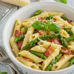 Pâtes aux asperges et bacon avec parmesan dans bol blanc élégant