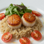 Pétoncles et quinoa au lait de coco élégamment dressés sur assiette blanche