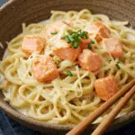Ramen crémeux au saumon et deux fromages dans bol fumant