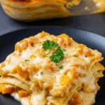 Lasagnes à la courge et au fromage gratinées dans un plat blanc avec fromage doré et couches visibles