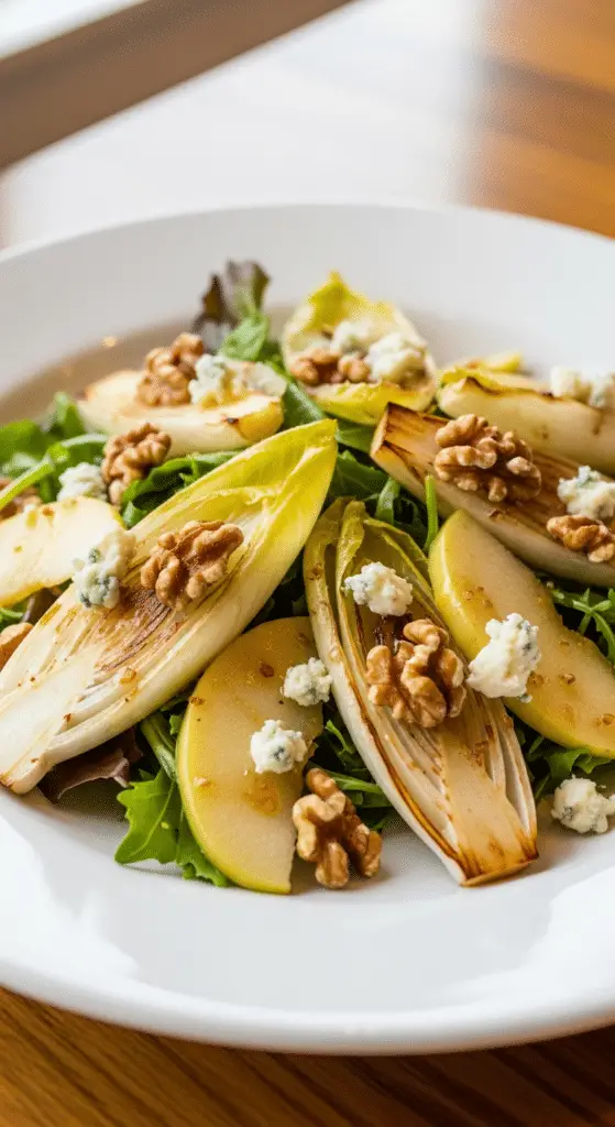 Service élégant salade endives rôties pommes noix fromage bleu