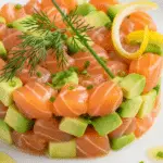 Tartare saumon frais avocat citron dressé cercle microgreens élégant