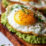 Toast avocat œuf au plat croustillant jaune coulant sur pain grillé graines